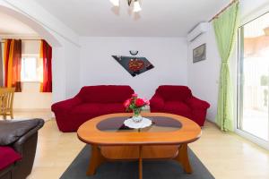 a living room with a table and red chairs at Kuća za odmor Pixie in Vrsi