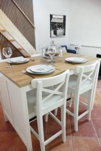 a white dining room table with two chairs and wine glasses at Kalpic Suites & Villa in Lozovac