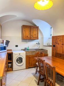 uma cozinha com uma mesa e uma máquina de lavar roupa em Orchidea em Finale Ligure