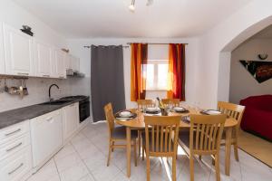 a kitchen and dining room with a table and chairs at Kuća za odmor Pixie in Vrsi