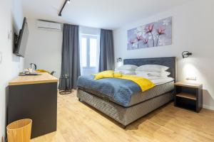 una camera da letto con un letto con coperte e cuscini gialli di 2M Exclusive Rooms a Zara (Zadar)