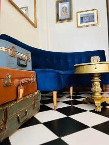 um sofá azul sentado num piso xadrez com bagagem em Hotel Casa Aure em Santiago