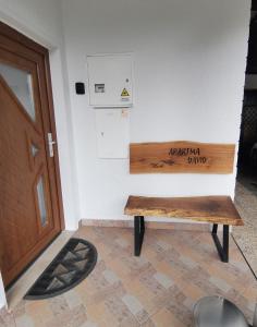 einer Holzbank vor einer Tür in der Unterkunft Apartma David in Most na Soči