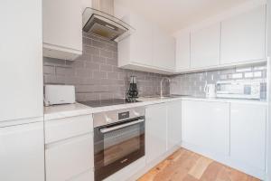 a white kitchen with white cabinets and appliances at Central Eastleigh 1 Bedroom Apartment in Eastleigh