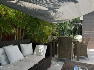 a patio with wicker chairs and a couch under a canopy at Appartement Clostelle in La Gaulette
