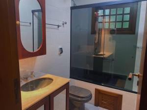 y baño con lavabo, aseo y espejo. en Apartamento aconchegante Gramado, en Gramado