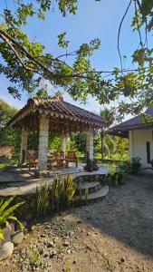 a pavilion with a table and benches in a yard at White house Sumatra Bukit Lawang in Timbanglawang