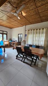 a living room with a wooden table and chairs at White house Sumatra Bukit Lawang in Timbanglawang