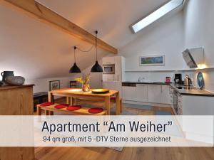 a kitchen with a wooden table and a dining room at Maisonette-Wohnungen "Beim Schmied" im Chiemgau in Traunreut