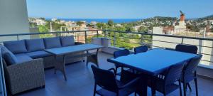 a balcony with tables and chairs and a view of the city at Petros House Artemis - Near the Airport in Artemida