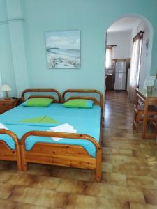 a bed in a room with a blue wall at ANATOLI ROOMS SERIFOs in Serifos Chora