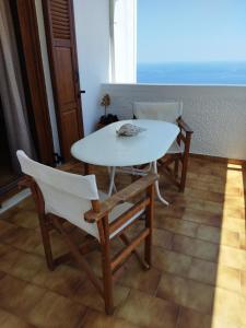 a white table and chairs in a room at ANATOLI ROOMS SERIFOs in Serifos Chora
