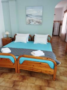a bedroom with a bed with blue walls at ANATOLI ROOMS SERIFOs in Serifos Chora