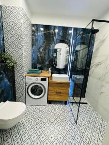 a bathroom with a washing machine and a mirror at Apartamenty Dębowa 18 in Milicz