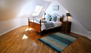 a bedroom with a bed and a rug on a wooden floor at Coorie Cottage- stylish townhouse Anstruther in Anstruther