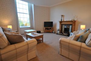 a living room with two couches and a tv at Kirkmay House Apartment in Crail