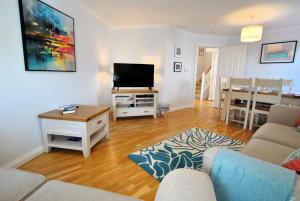 a living room with a couch and a tv at Coorie Cottage- stylish townhouse Anstruther in Anstruther