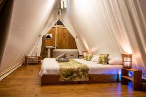 um quarto com uma cama numa tenda em Quimera Glamping em Pacuar