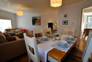 a dining room and living room with a table and chairs at Coorie Cottage- stylish townhouse Anstruther in Anstruther