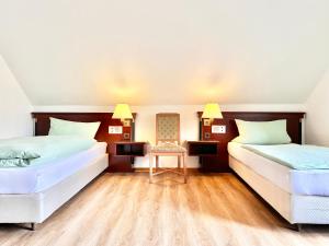 zwei Betten in einem Zimmer mit Holzboden in der Unterkunft Ferienwohnung 2-4 Pers WLAN und Parkplatz, HDZ und Kliniken in der Nähe, direkt an der A2 und A30 gelegen in Löhne