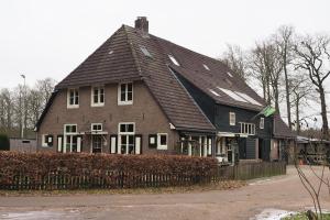 duży brązowy dom z czarnym dachem w obiekcie Boerderij de Enkhoeve w mieście Laag-Soeren