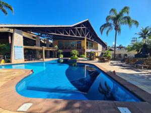 a swimming pool in front of a building at Ilha Flat Hotel in Ilhabela