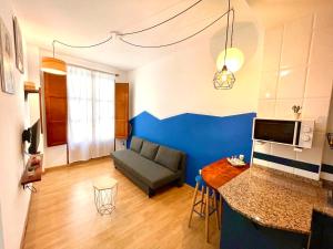 Catedral Apartments في فالنسيا: غرفة معيشة مع أريكة والجدار الأزرق