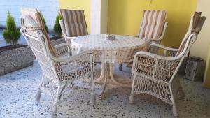 una mesa con 4 sillas y una mesa y sillas blancas en Helena, en Trzin