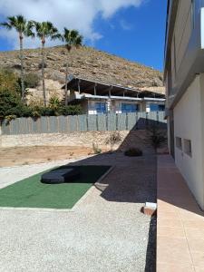 a house with a green lawn in front of a building at Villa Ipanema Benidorm in Finestrat