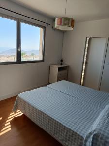 um quarto com uma cama e 2 janelas grandes em Villa Ipanema Benidorm em Finestrat