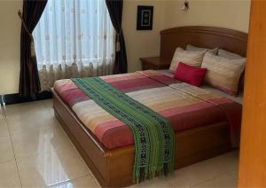 een slaapkamer met een bed met een deken erop bij Sekar Wangi Homestay in Sleman