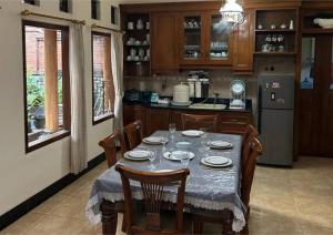 una cocina con mesa y algunas sillas y una cocina con en Sekar Wangi Homestay en Sleman