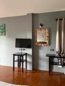 a living room with two tables and a television at Retro guesthouse in Pattaya South