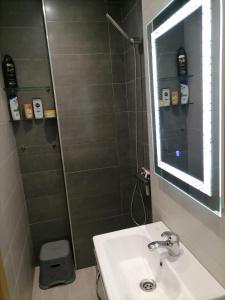 une salle de bain avec un lavabo et une douche avec un miroir dans l'établissement Fnideqrelax, à Fnideq 12 autres photos