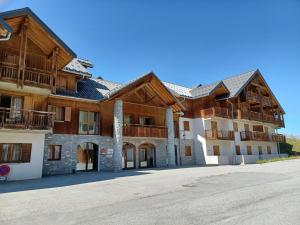 duży drewniany budynek z mnóstwem okien w obiekcie Studio confortable à 300m des pistes avec terrasse et parking - FR-1-618-25 w mieście Albiez-Montrond