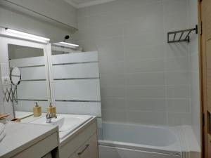 een witte badkamer met een wastafel en een bad bij M Suites in Cluj-Napoca
