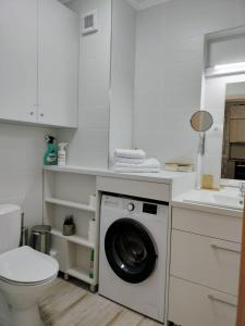 a white bathroom with a washing machine and a sink at M Suites in Cluj-Napoca
