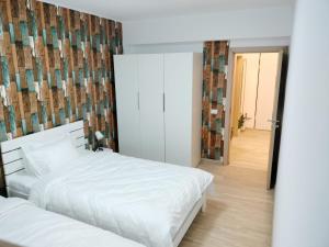 2 witte bedden in een kamer met een spiegel bij M Suites in Cluj-Napoca