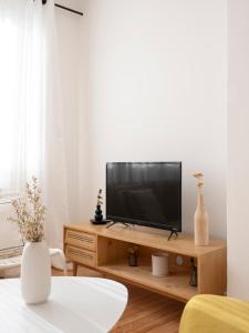 een woonkamer met een televisie op een houten standaard bij Au clair d'Augustin in Metz