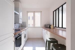 een witte keuken met een aanrecht en een raam bij Au clair d'Augustin in Metz