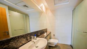 a bathroom with a sink and a toilet and a mirror at Dubai Creek Budget Apartment in Dubai