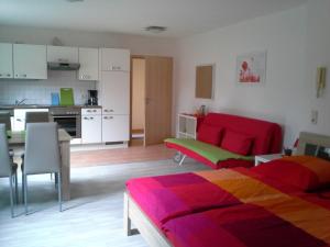 ein Wohnzimmer mit einem Bett und eine Küche in der Unterkunft Apartment Herdrich in Rust
