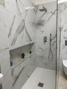 a bathroom with white marble walls and a shower at Villa Maremonti in Taormina