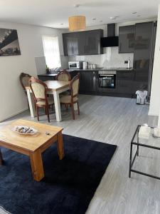 a living room with a table and a kitchen at Beautiful maisonette in Leeds