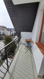 a balcony with two chairs and a wooden ceiling at Pokoje goscinne, apartamenty Jas i Malgosia in Karwia