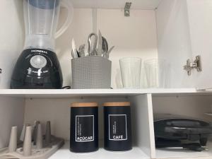 a kitchen shelf with a blender and other kitchen utensils at Pousada Bella Flor in Baía Formosa