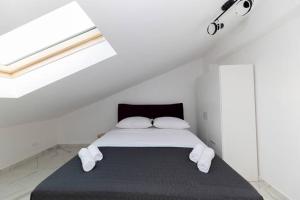 um quarto branco com uma cama com 2 almofadas em Roko house - Right next to the sea em Petrcane