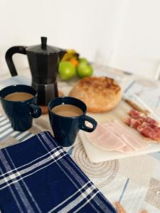 a table with two cups of coffee and a plate of food at Lighthouse in Puerto del Rosario