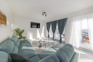 uma sala de estar com um sofá azul e uma mesa em Roko house - Right next to the sea em Petrcane