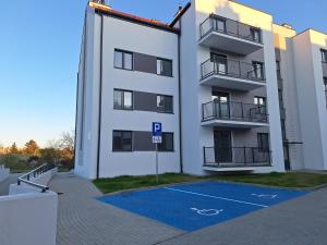 ein Apartmenthaus mit einem Basketballplatz davor in der Unterkunft SEA Apartment in Malbork